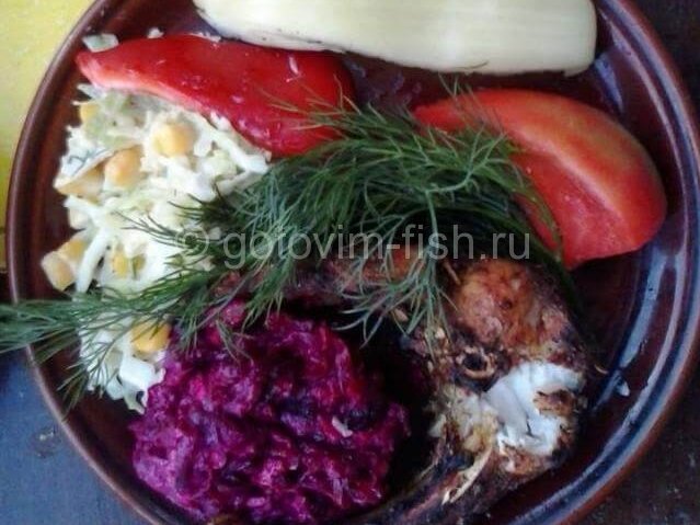 Толстолобик с овощами на тарелке